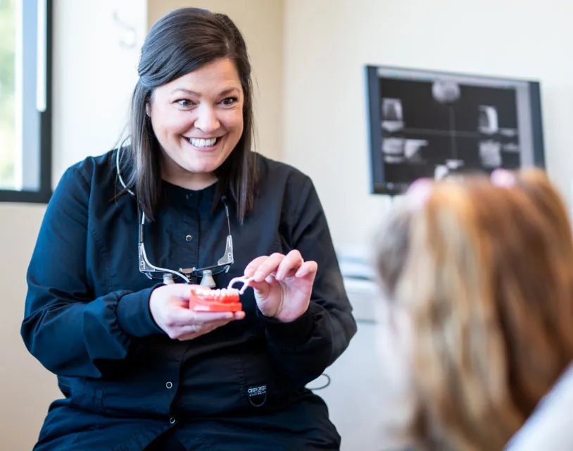 Dr. Taylor of Smile Source Spokane North Side showing a patient how to floss teeth