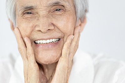 woman smiling after getting all-on-4 dental implants