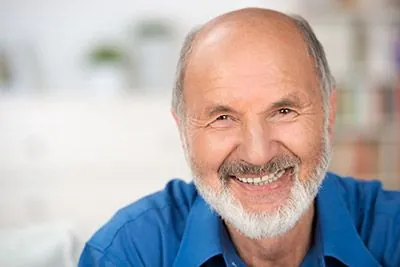 man smiling after dental implants helped restore his smile
