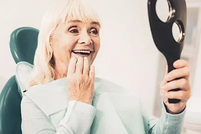 woman happy with the look of her new smile thanks to dentures