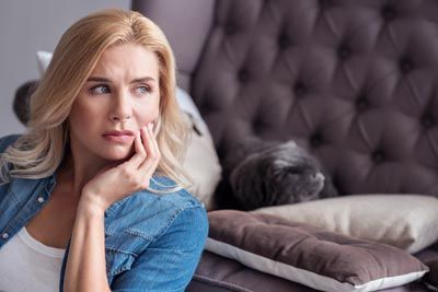 woman holding her mouth due to tooth pain